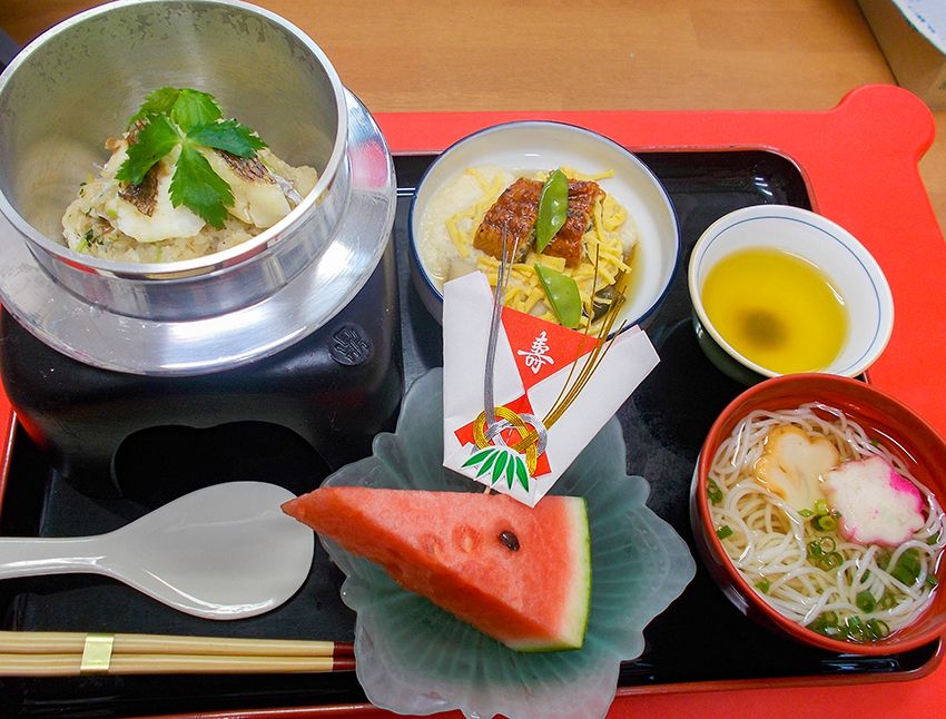 スイカのデザートが付いた、ちらしと釜めしと麺がセットになった特別食