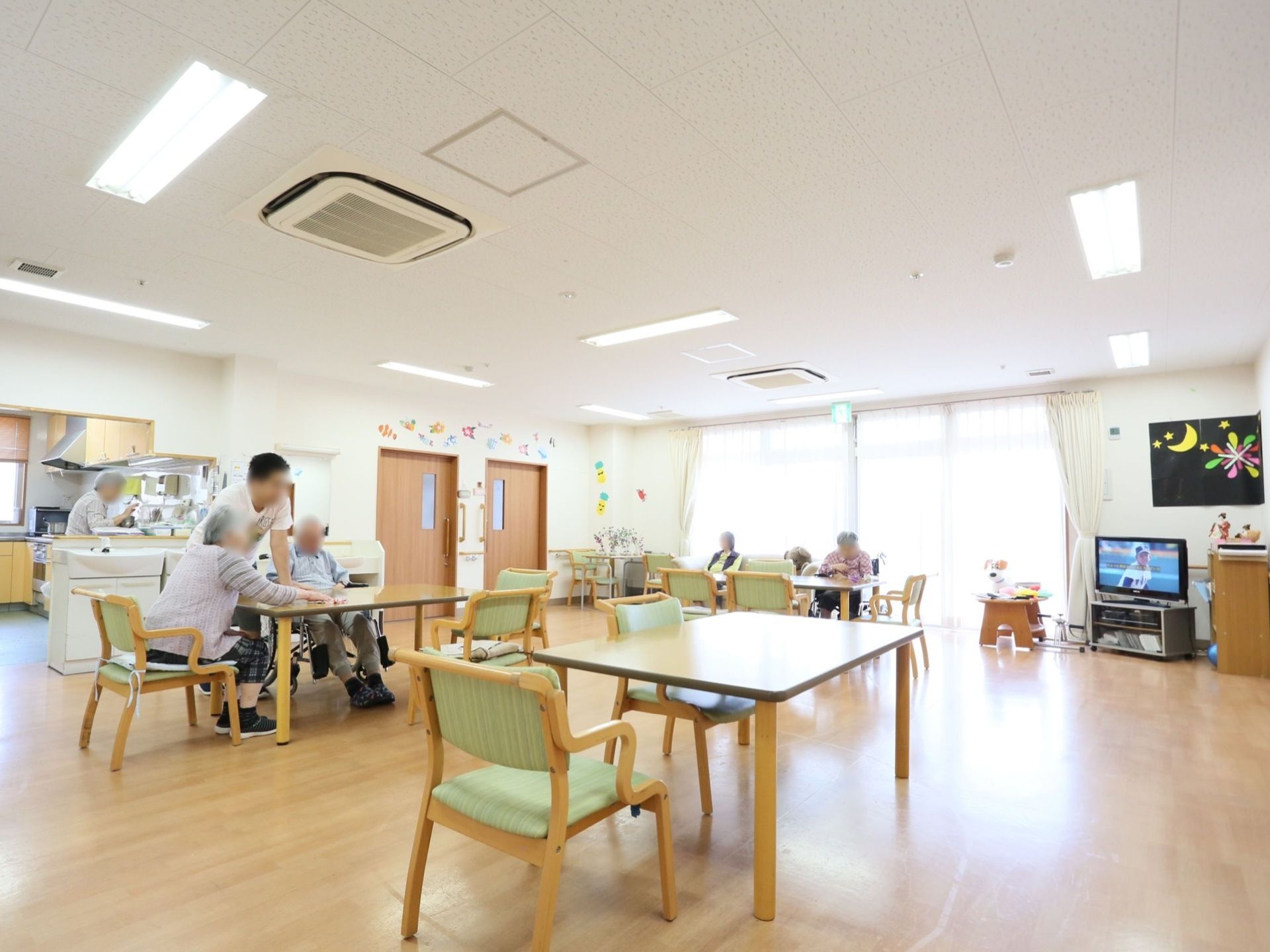 すぐ横に台所があり、出来立ての食事が楽しめる。入居者様も自由に出入りができ、スタッフと一緒に調理することもできる。