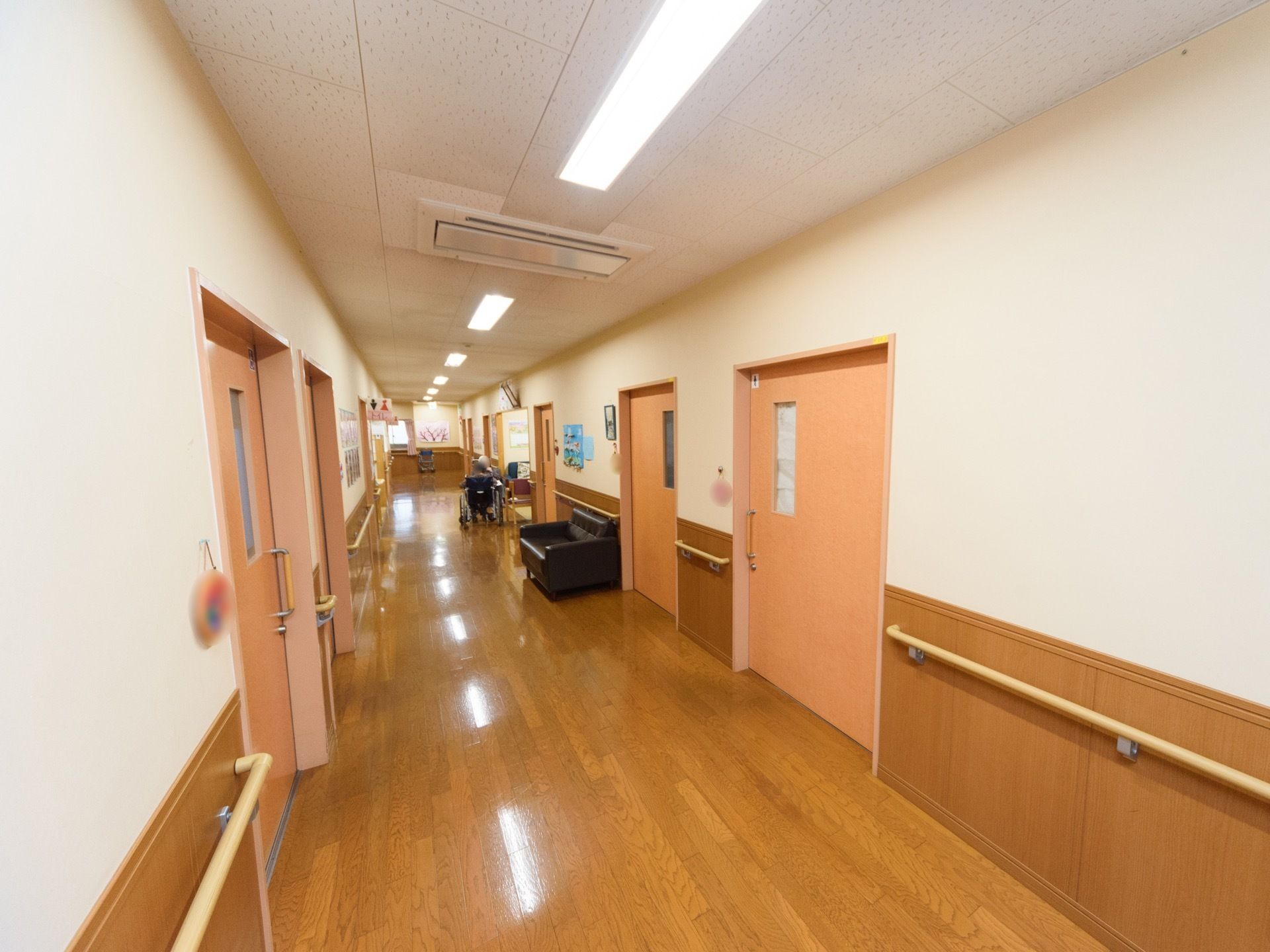 広く見通しの良い廊下である。両サイドの壁には、手すりが取り付けられている。ソファーが壁際に置かれている。