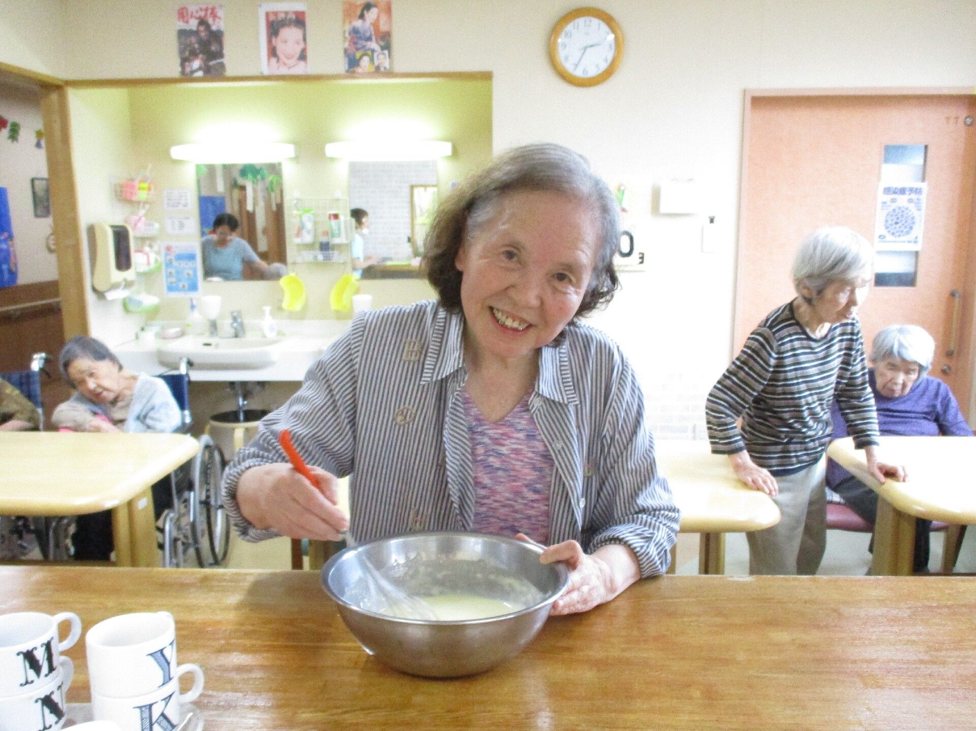 食堂のカウンターの上でボールの中のものを混ぜている女性入居者様