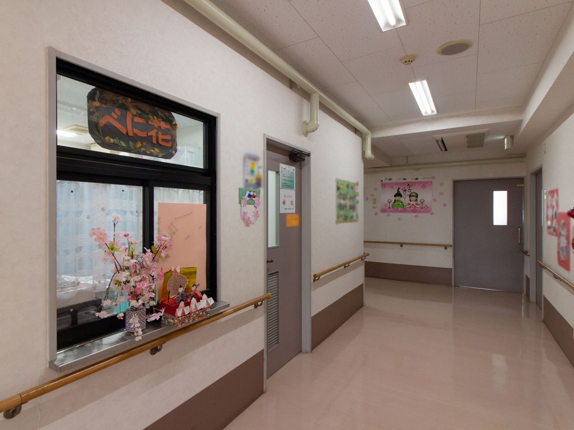 床はベージュで段差がなく、広々としている。壁には手すりが取りつけられており、左側にある小さなカウンターの上にひな祭りの飾りが置かれている。
