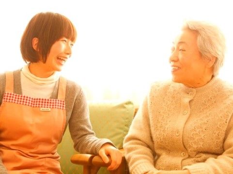 並んで座って談笑している女性入居者様と女性スタッフ