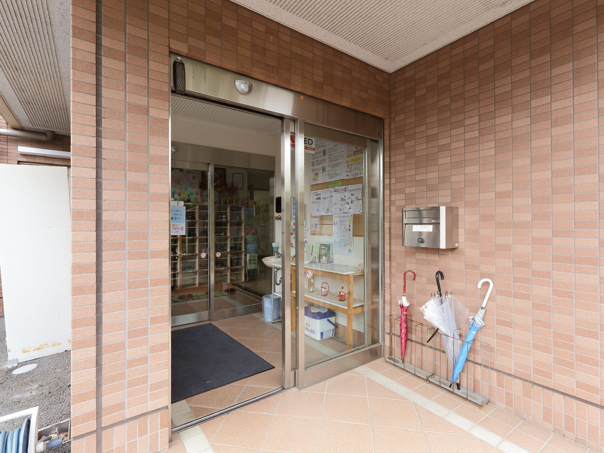 玄関出入口前横に郵便受けが備えられ、二重ドア構造になっている。館内前の中スペースには、洗面台が設置あれ、壁には広告などが貼られている。