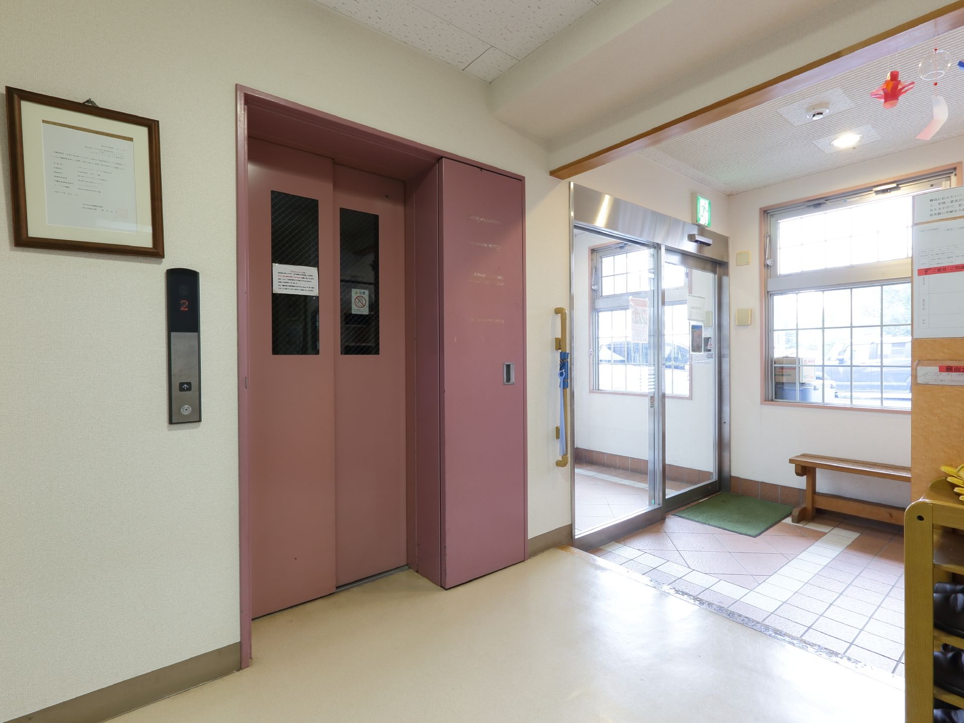 玄関上り口傍に設けられたエレベーターホールである。横の壁には縦に手すりが設置してある。横面には窓が広がっている。