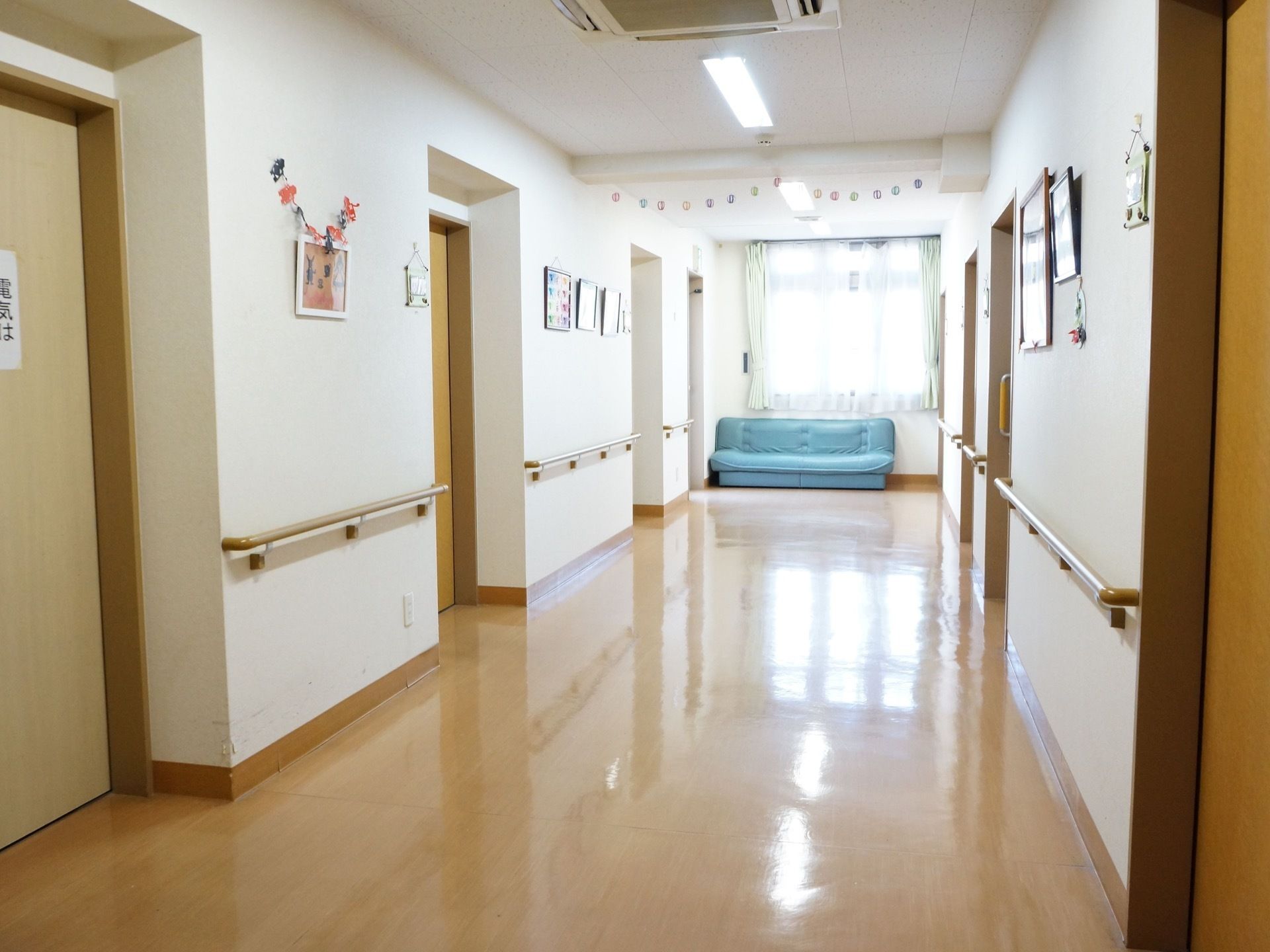 広い通路となっている。車椅子の人が利用しやすい作りである。床には段差がなく安全である。窓際にソファーを置いている。