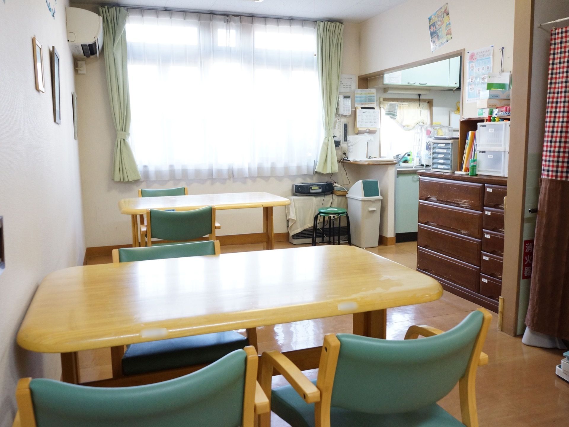 窓があるので光が入り、明るい空間となっている。段差がなく、床はフラットとなっている。横にはキッチンがある。