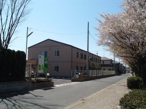 道路の反対側に季節を代表する花が満開になっている施設の全体外観