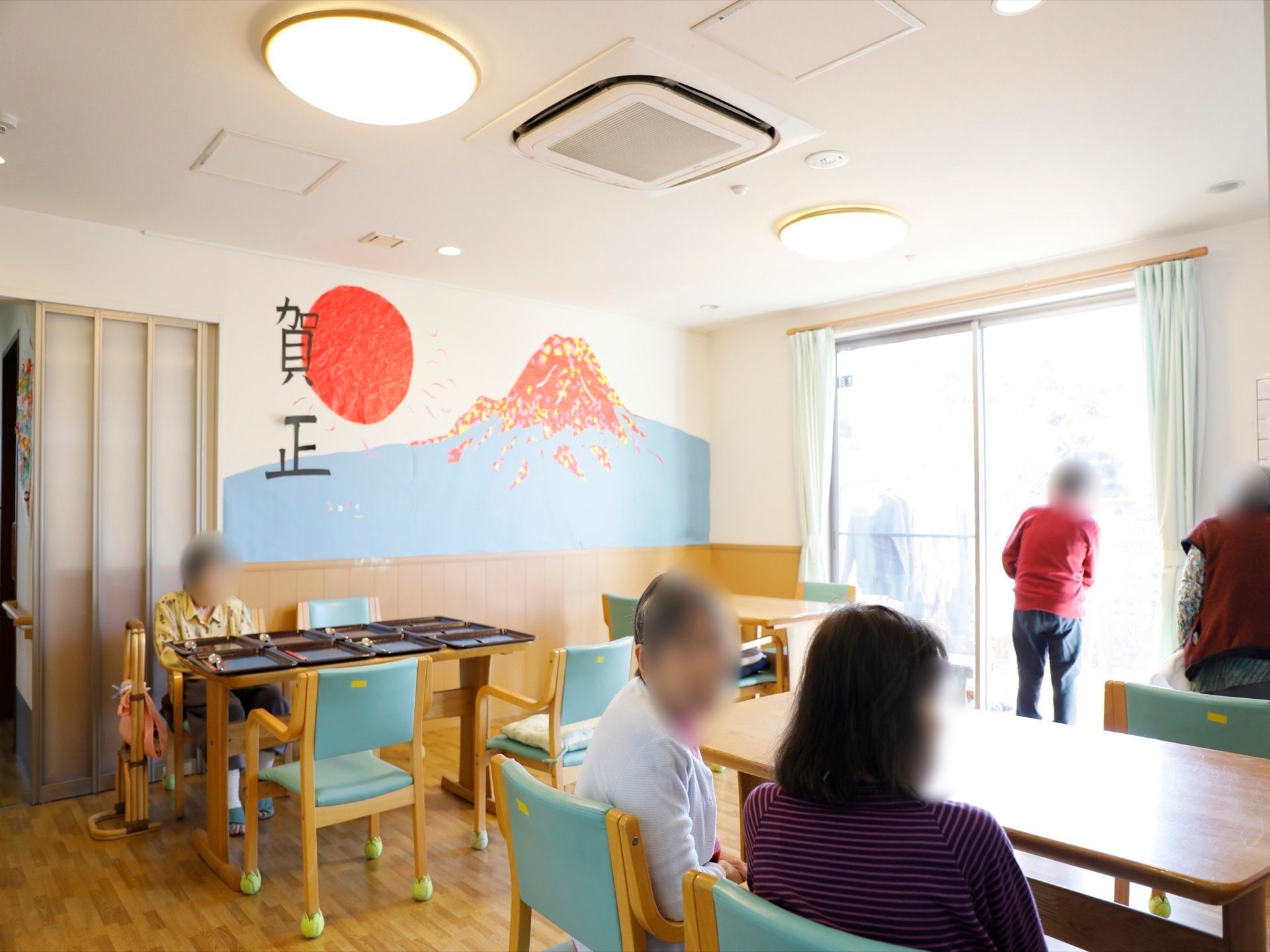 食堂の壁に折り紙などを使用し作った富士山の作品が飾られている。スタッフが案を出し、入居者様と作成している。