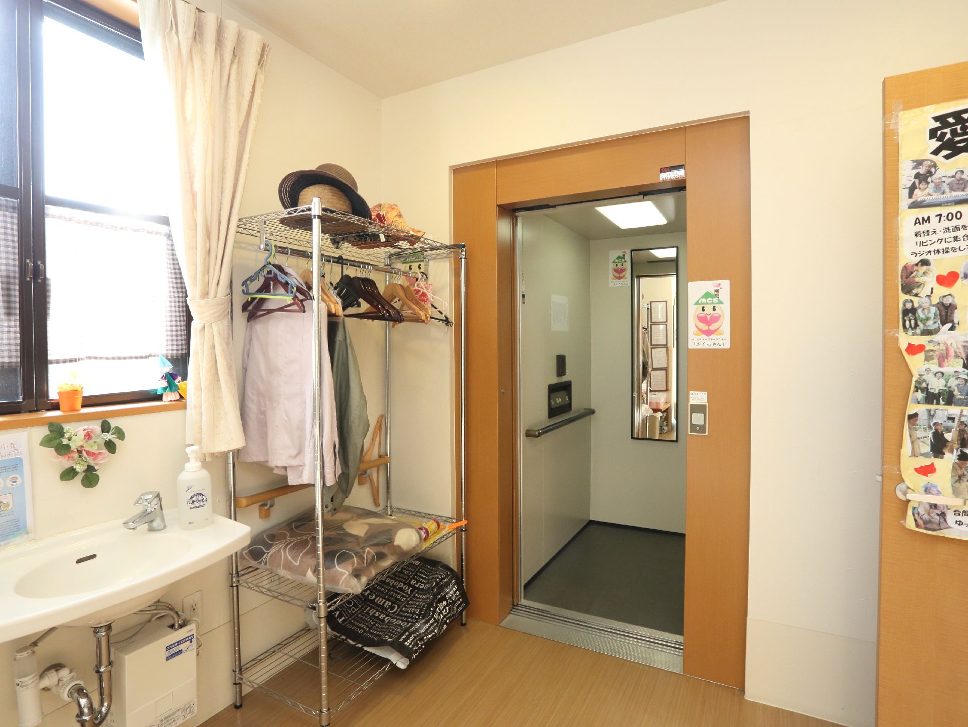 エレベーターが設置されている。中には手すりがついている。奥には鏡がついている。ボタンは押しやすく大きめ。