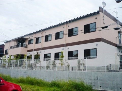 周りより少し高くなっている敷地面に立地している２階建ての施設外観