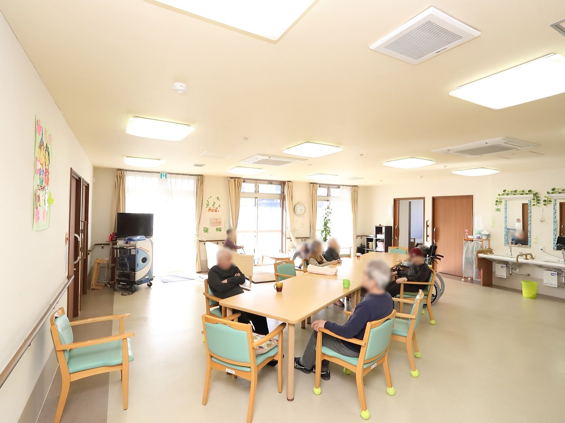 共有スペースには、掃き出し窓が３組あり、そのうちの一つは非常口になっている。大きな鏡がついた洗面台が２つ設置されている。