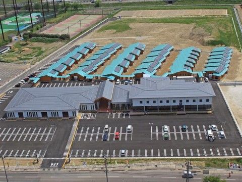 敷地内に多くの駐車スペースが整然と並んでいる施設の上空からの写真