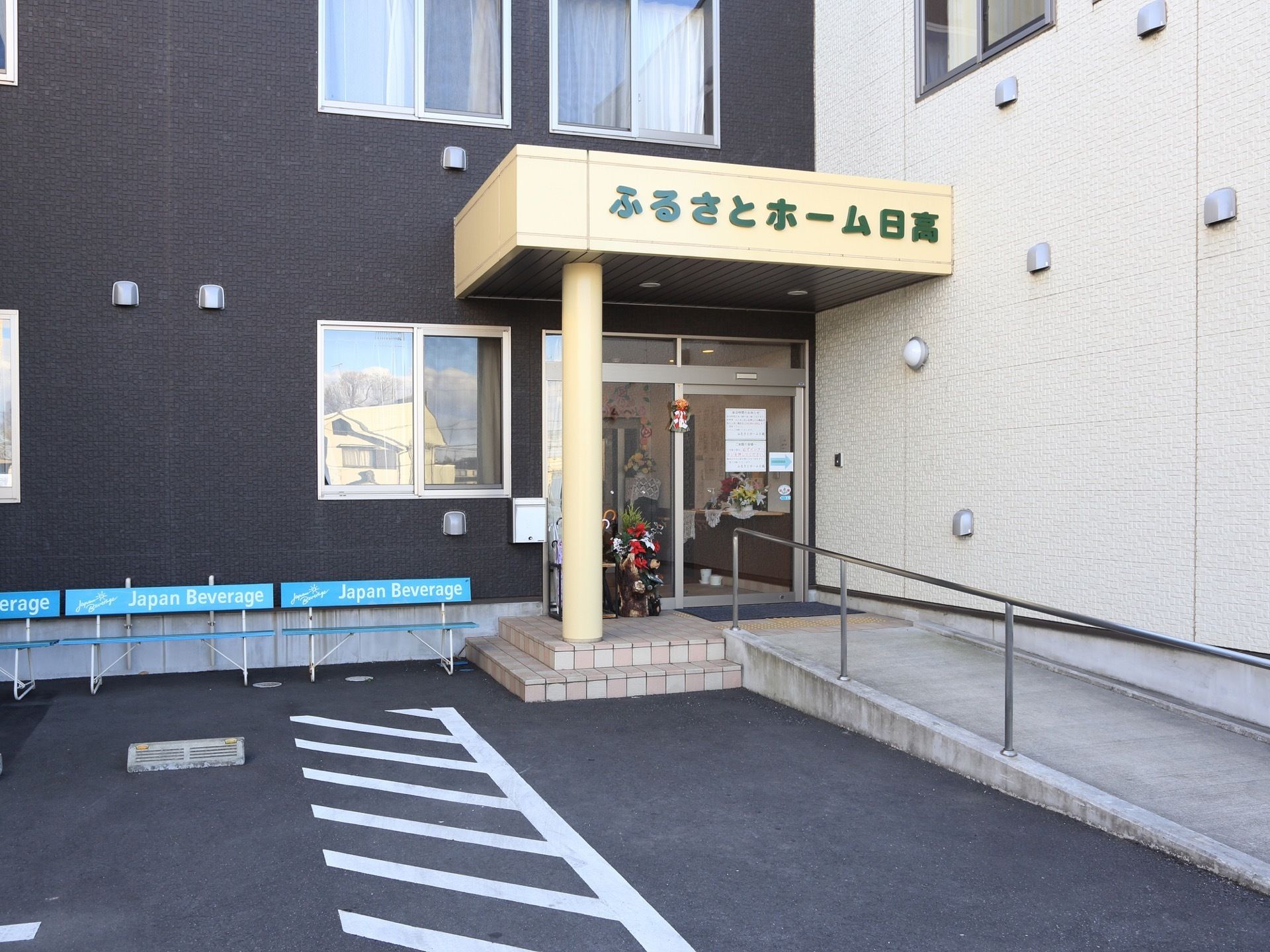 入り口は自動ドアになっており、アプローチには手すりが取り付けられているスロープが設置されている。入り口の前には駐車スペースがある。
