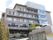 坂をのぼった先に建てられている、マンション風の５階建ての建物。窓が多く取り付けられており、外光が十分に室内に入るよう配慮されている。