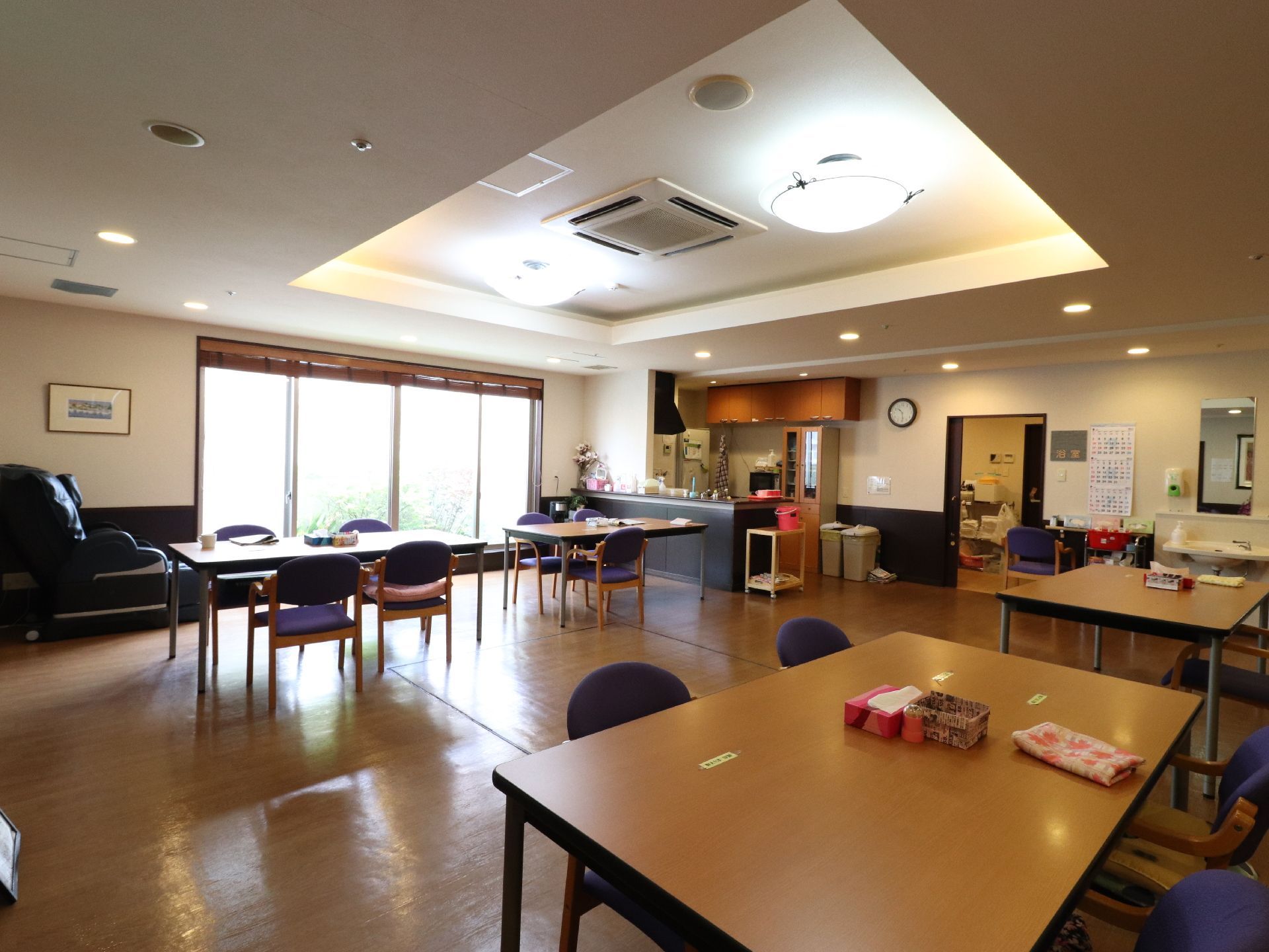 大きい窓から入り込む光が明るい空間にしている。マッサージチェアも置いてある。くつろぐのにぴったりの空間である。