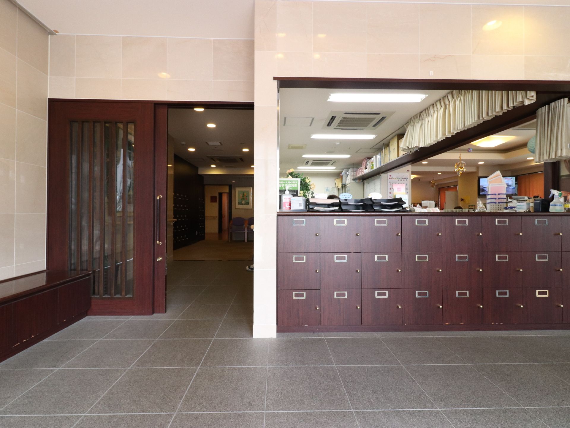 大きな引き戸は、エントランスの出入口である。来客用の下駄箱がある。引き戸の手前に箱状の家具が置いてある。