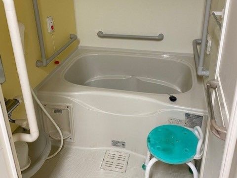 淡いピンクと黄色のタイル張りの浴室である。浴槽が備わり、洗い場にはシャワーがある。洗い場の壁には鏡が取り付けられている。