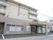 4階建ての施設で、前には駐車場がある。玄関前には屋根がつけられている。居室にはベランダがある。建物前に自転車が置かれている。