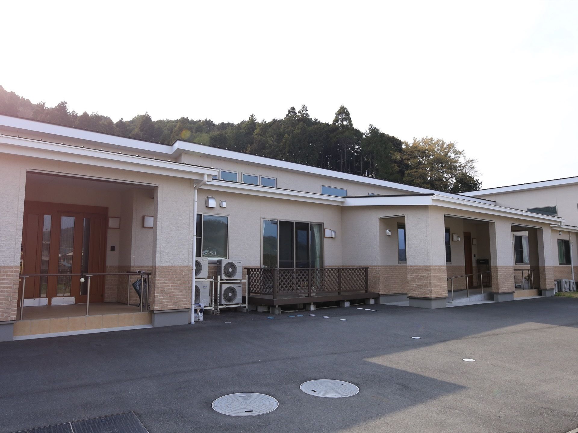 白を基調とした平屋建てのモダンな建物である。エントランスまではスロープが完備されている。ウッドデッキが設置されている。