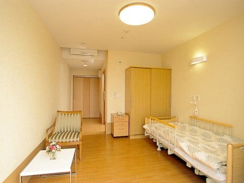 ベッド、タンス、電話台、テーブルセットなどがすっきりと配置されたひとり用居室