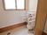 フラットなフロアにトイレスペースがある。小便器の両側と上部には手すりがあり、右側には壁の仕切りが設けられている。