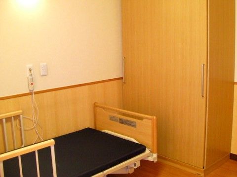 ベッドの向かいに引き戸の大きなクローゼットが備え付けられた居室
