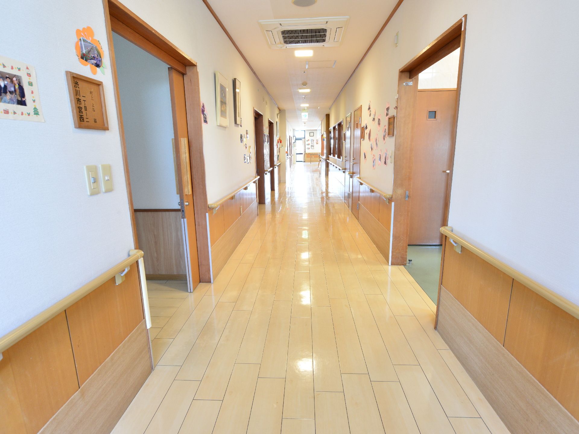 施設の廊下は幅広で車椅子が二台ほど並べる広さがある。壁には全て手すりが設置されていて両側には居室の扉が奥まで並んでいる。