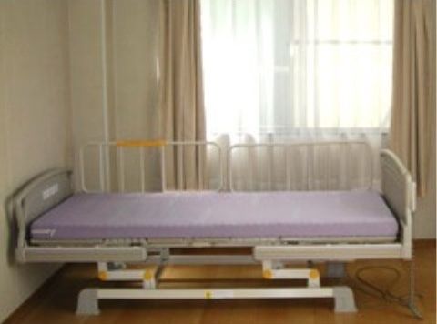 大きな窓から自然光の入るベッドの配置された部屋