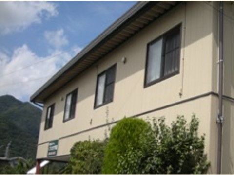 大きな一軒家を思わせる外壁がベージュ色の２階建て施設