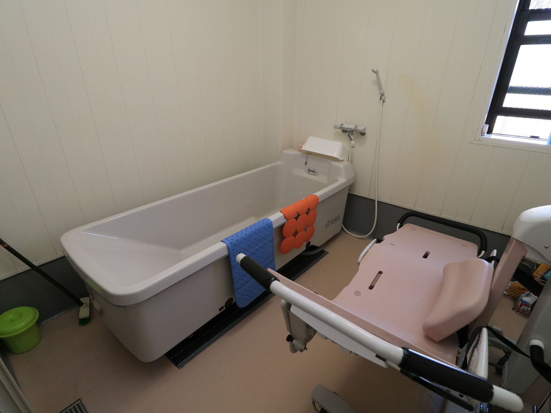 陽射しがよく入る窓が完備された清掃後の浴室の様子。介護入浴機器と介護浴槽が設置された特殊浴室である。