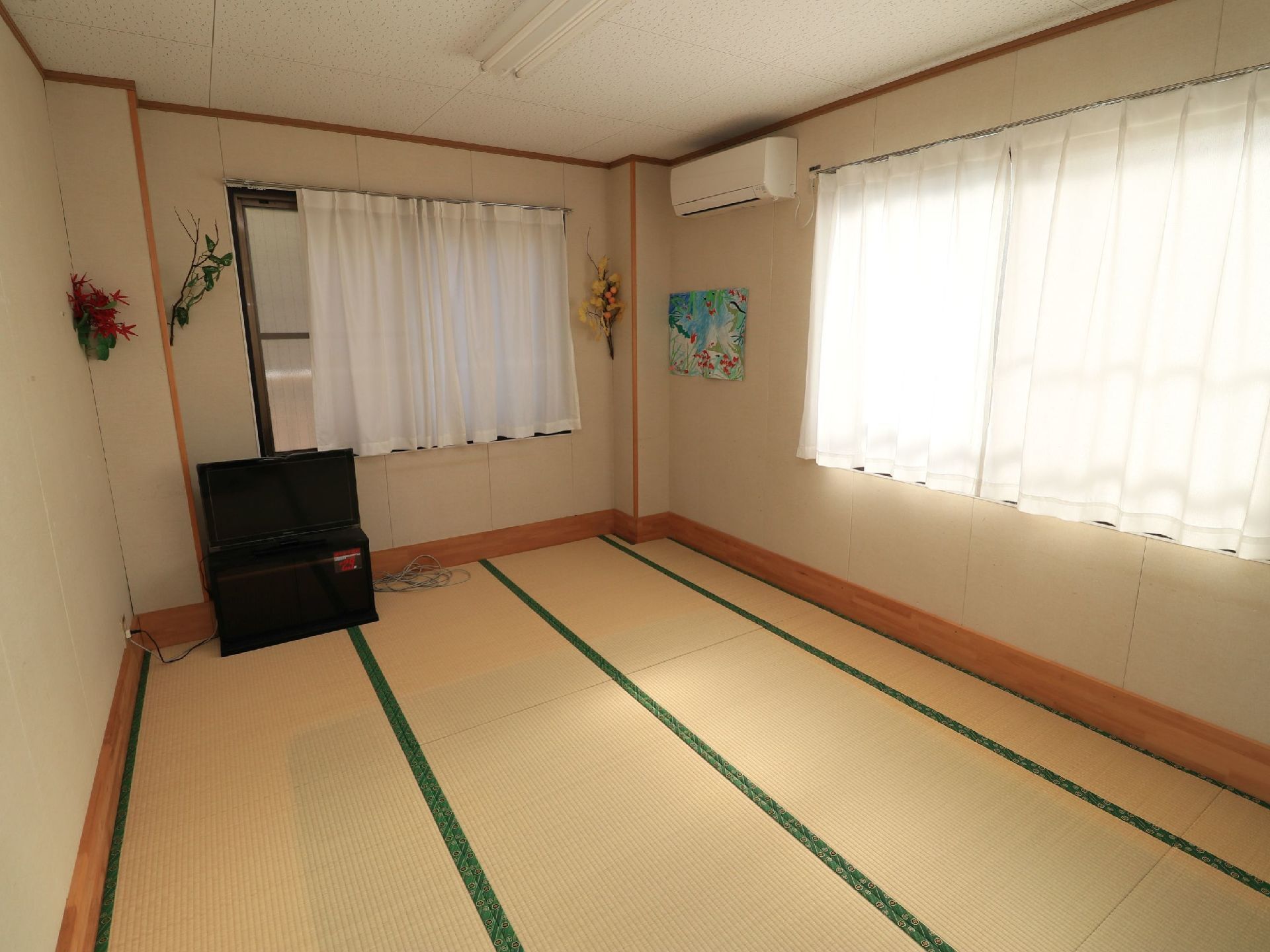 ベッドを壁に寄せて配置して、部屋をより広く利用できるようになっている。安全のために転落防止柵が設置されている。