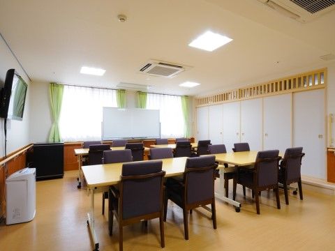 広々とした空間に、４人掛けのダイニングテーブルが4セット設置されている。ホワイトボードや空気清浄機も設置されている。