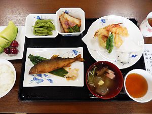 魚の煮つけと天ぷらの盛り合わせにメロンのデザートが付いたメニュー