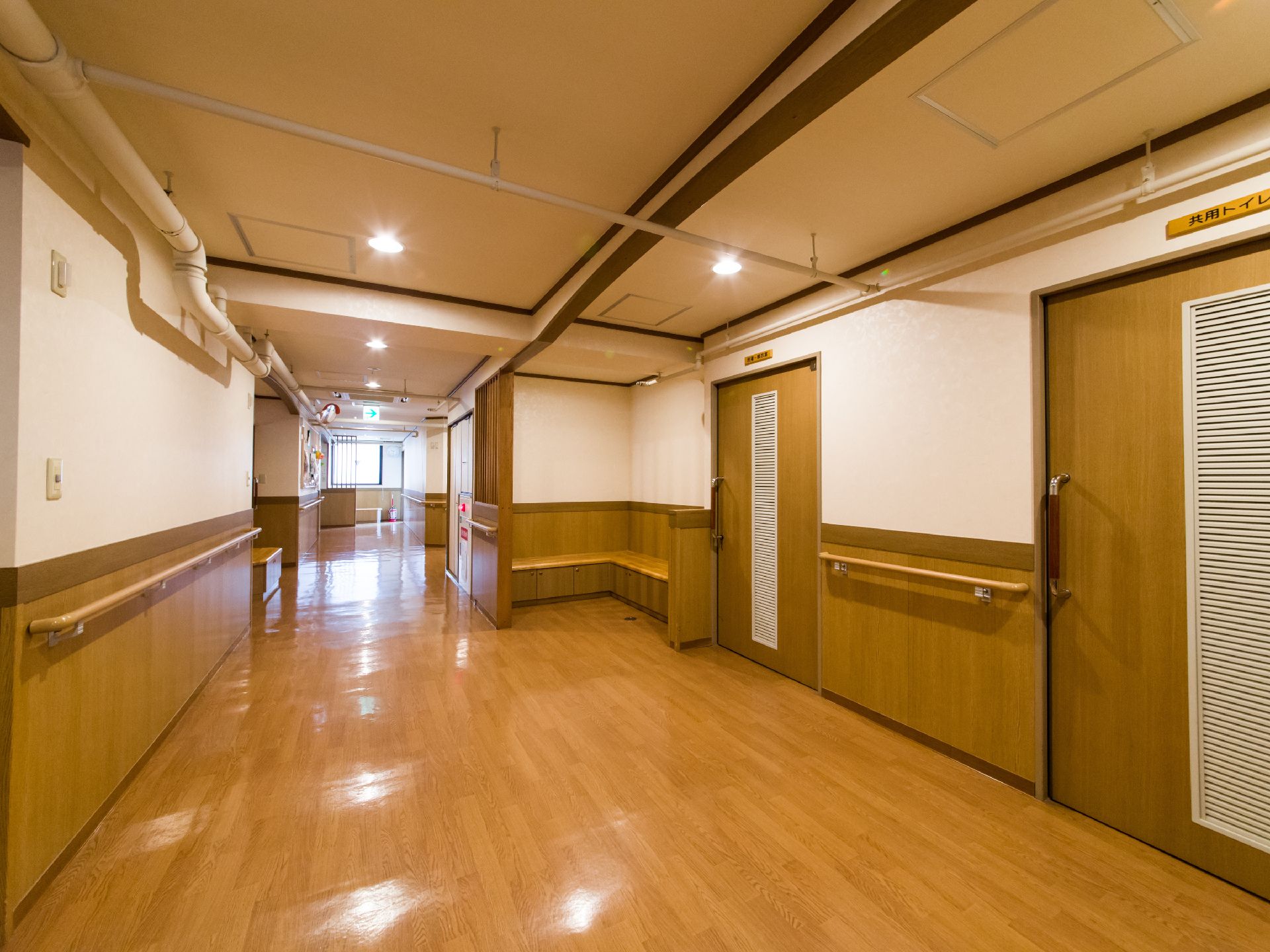 廊下には扉の横にL字型のベンチが設置された場所がある。横は壁で区切られており、1方向が解放された空間となっている。