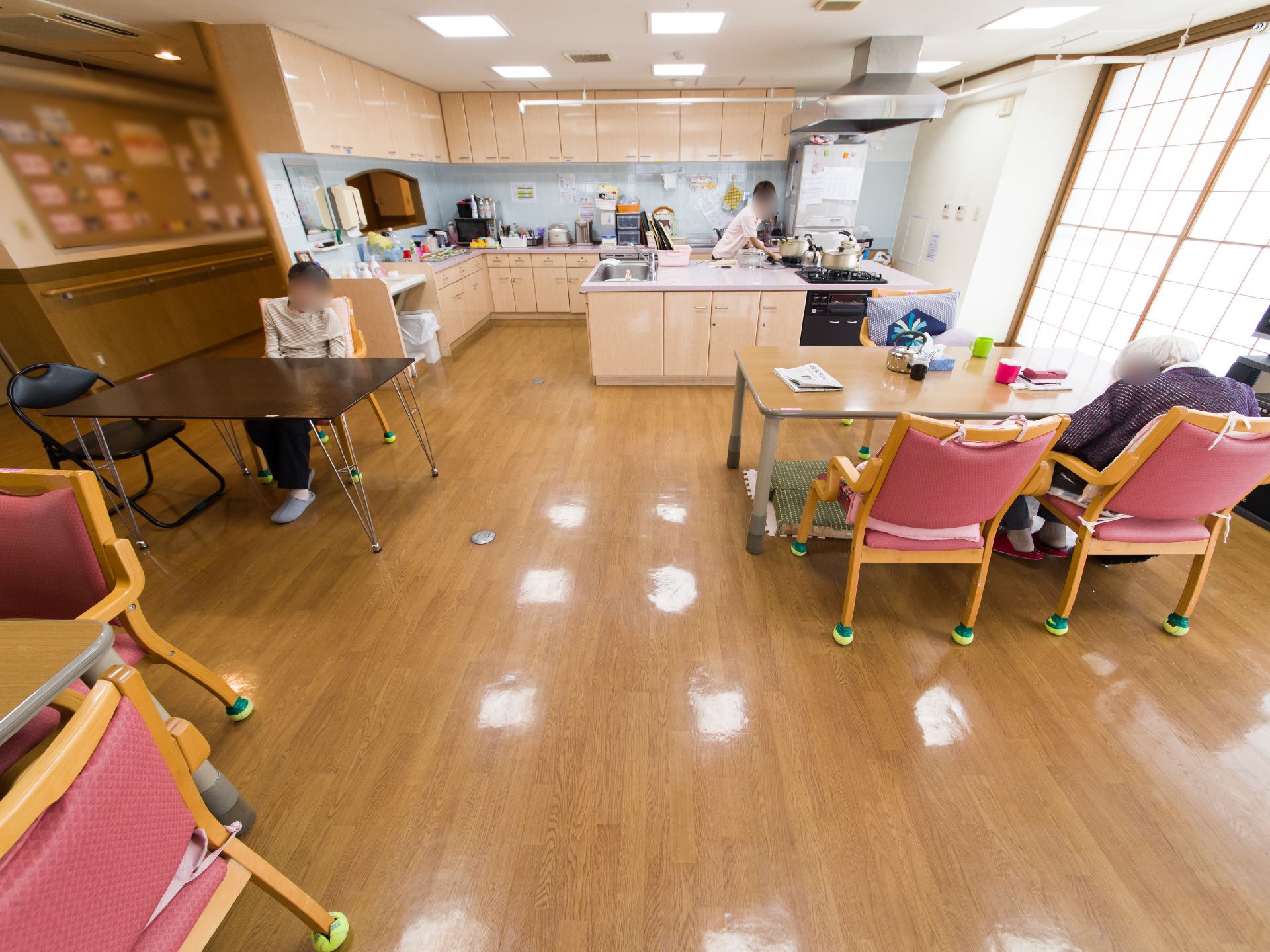 リビングの床は全面フラットなフローリングである。テーブルの間隔は車椅子が安全に通れる空間が確保されている。