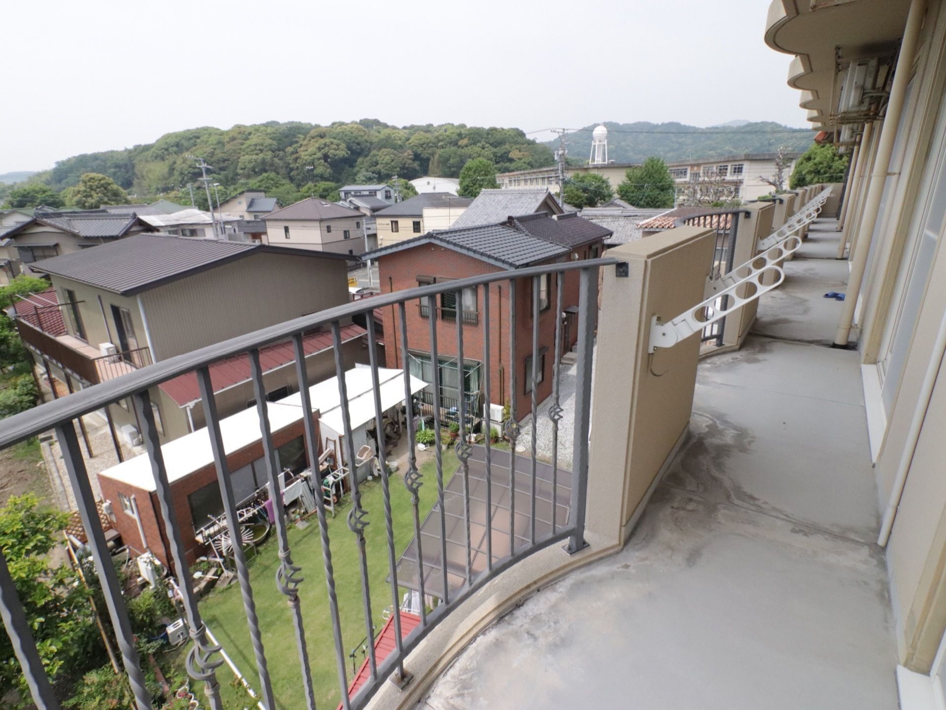 ベランダは他の部屋と繋がっており、転落防止の柵が取り付けられている。物干しざお受けが各部屋ごとに設置されている。