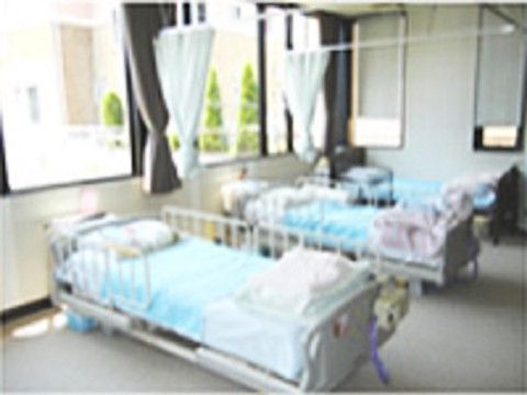 ベッドの間をカーテンで仕切ることができる、窓が大きく開放的な相部屋の居室