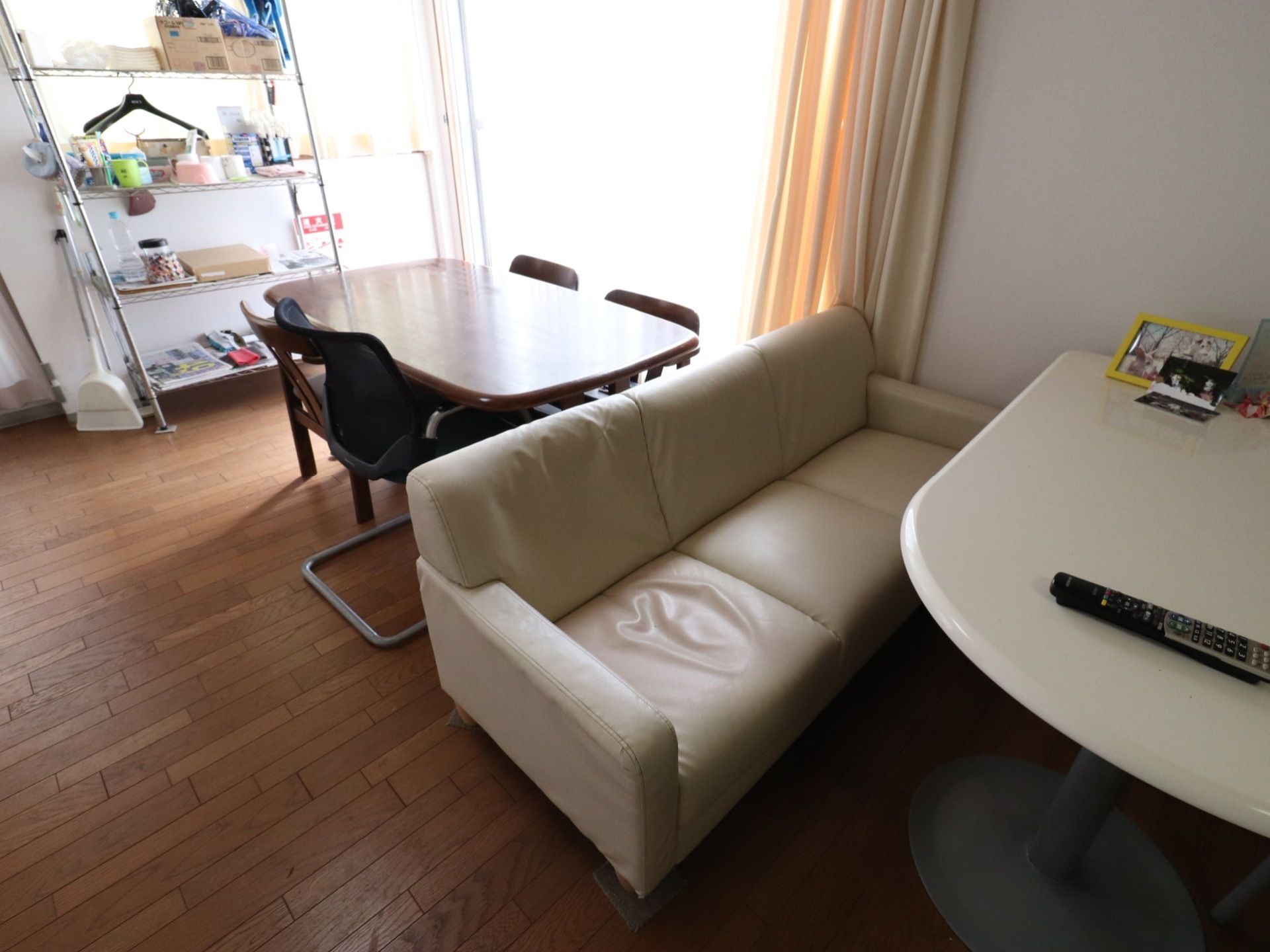 居室には白いテーブルとソファが置かれており、その上に写真が飾られている。また、ラックがあり、好きなものを置いておけるようになっている。