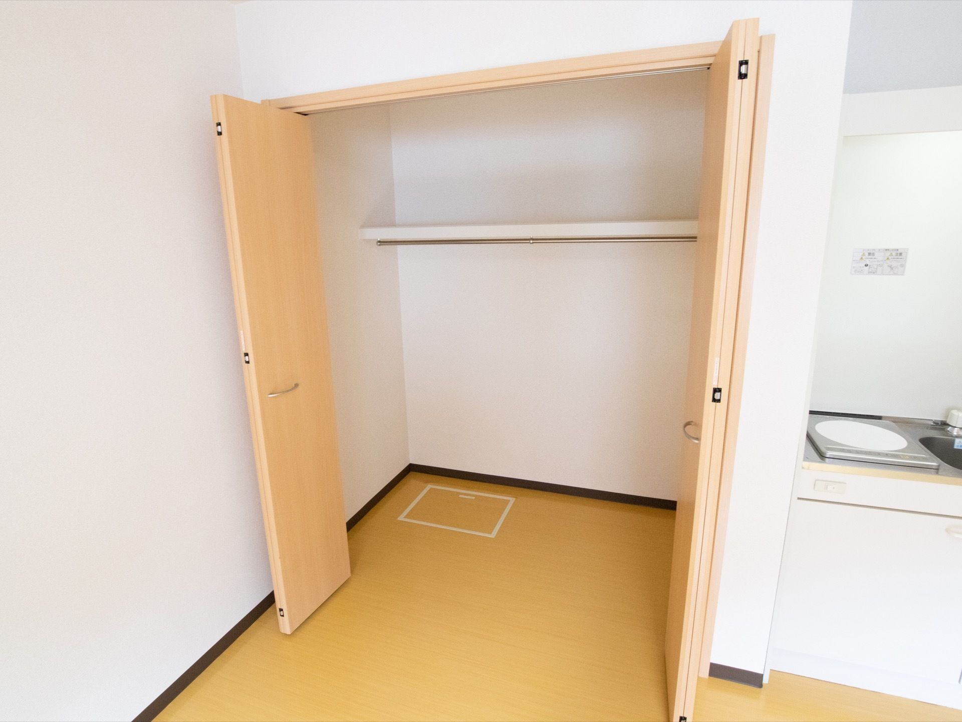観音開きの扉が使用されたクローゼットがあり、コート類を掛けられるポールが設置されている。クローゼットの隣にキッチンがある。