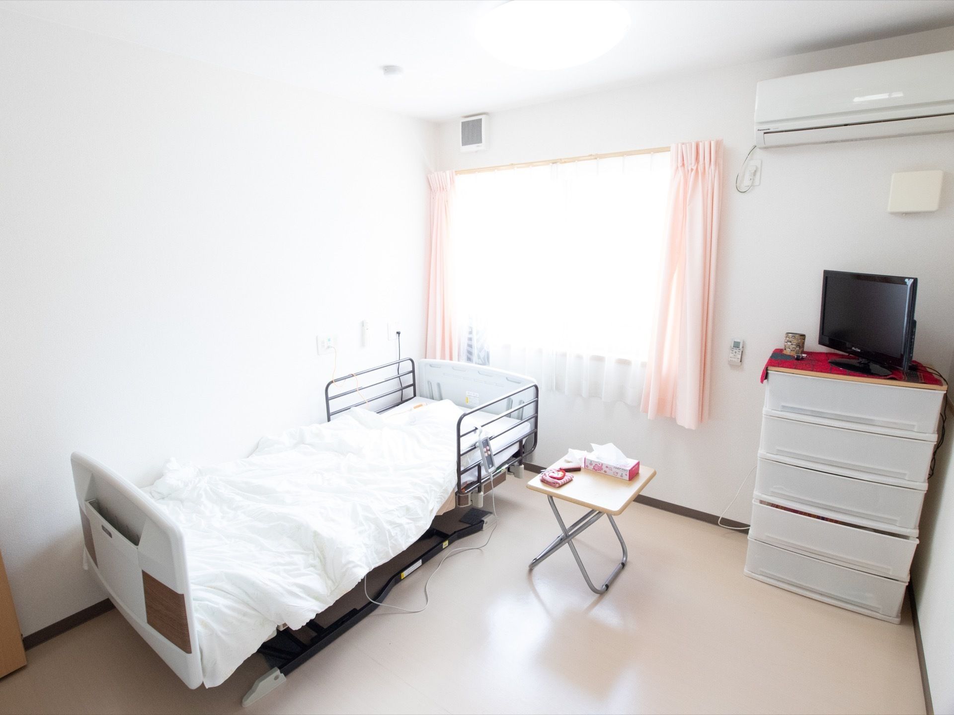 腰高窓から明るい光が入る、すっきりとした居室の様子