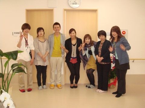 施設の一角でポーズを取って笑顔で写真に写る施設スタッフ