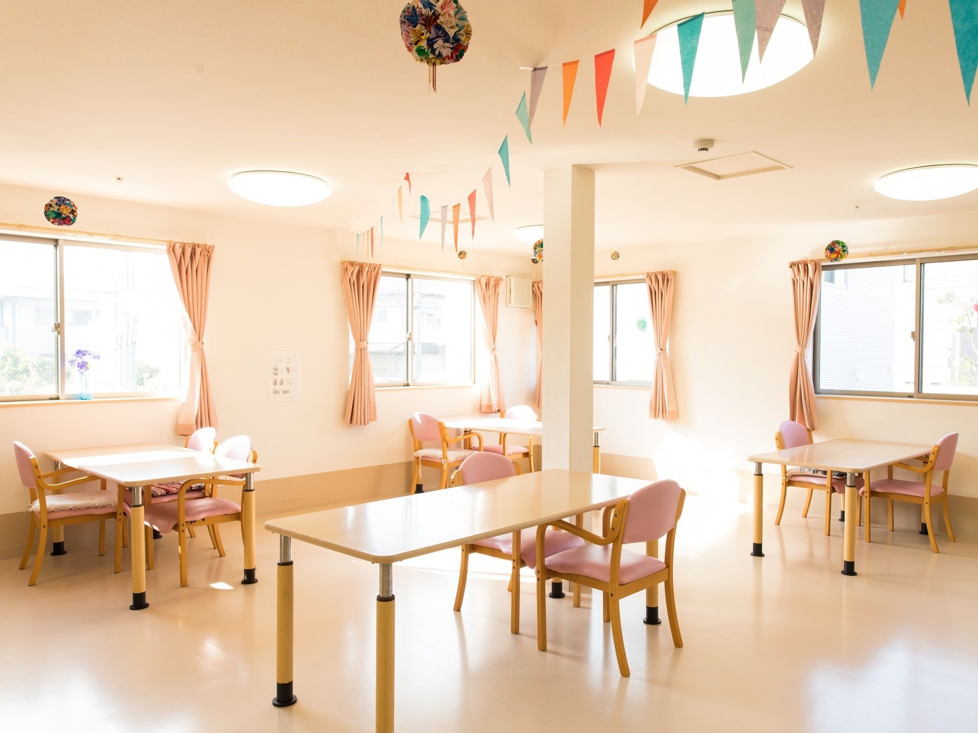 照明が明るい一室にスタッフお手製の折り紙の装飾が天井に飾られており、賑やかな雰囲気が演出されている。