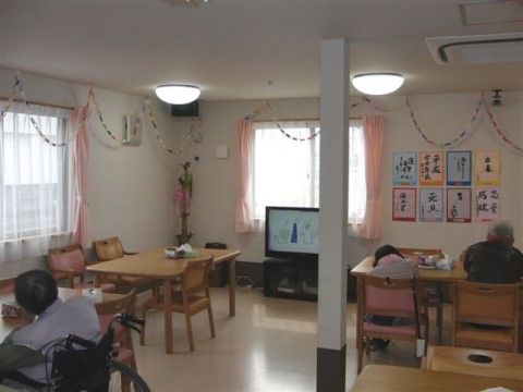 壁面にご入居者様の習字が飾られているテレビのある食堂