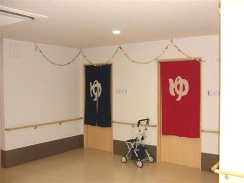 男湯と女湯にしっかり分けてのれんを掛けた入口に手すりのある廊下