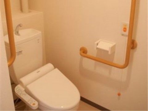 白い壁面に手すり、温水洗浄便座とナースコールがある居室トイレ