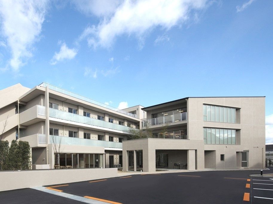 チャーム長岡京の外観。大きな病院のような、清潔感溢れる施設外観です。エントランスには大きなルーフがあり、雨の日も車の乗降が楽に出来ます。