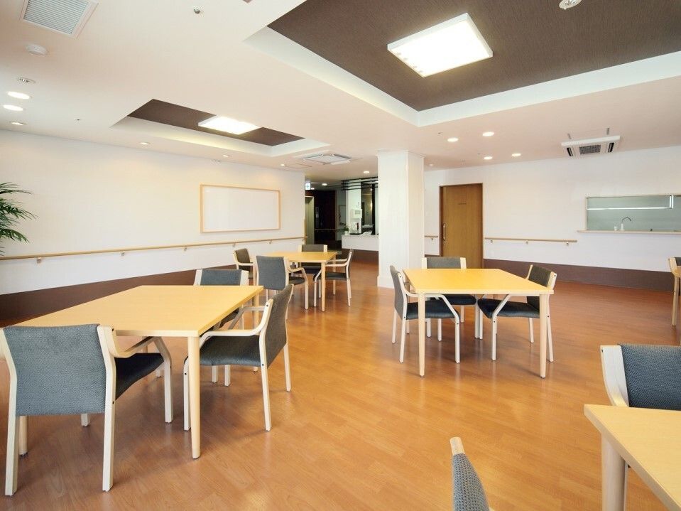 壁に手すりのあるレクレーションにも使う広々とした食堂