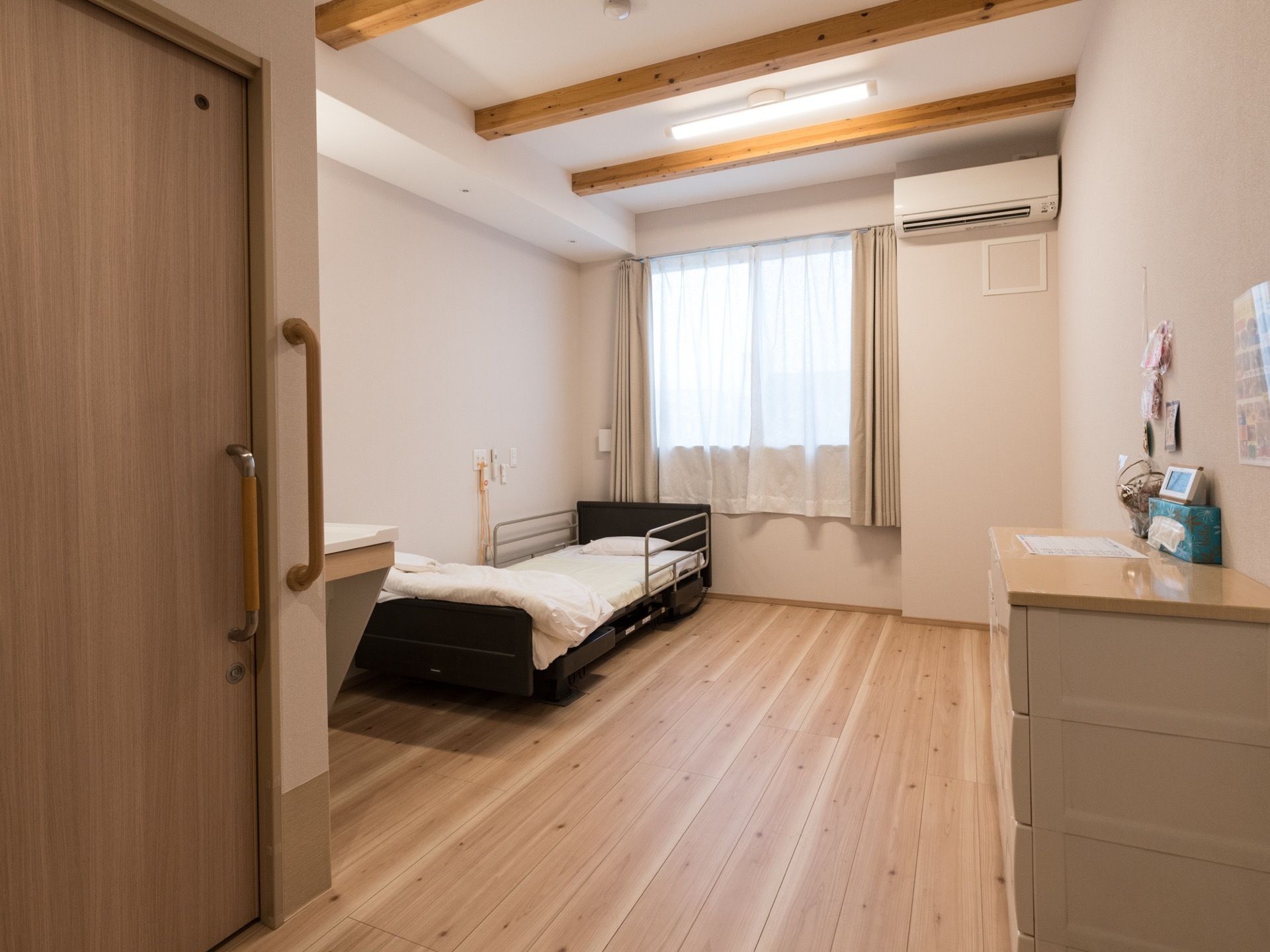 木の温もりを感じることができる部屋にはエアコンを完備し、一年を通して快適に過ごすことができる。腰高窓があり光が差し込み明るい部屋である。