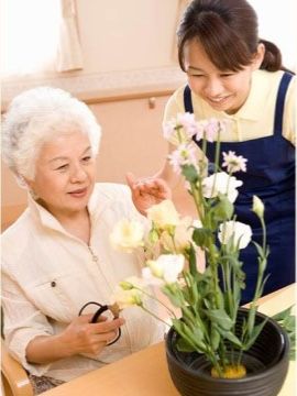 笑顔で花を手入れする様子
