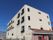 ベージュの外壁が眩しい４階建ての建物である。正面玄関の周りにはレンガを使用するなど、西欧風の外観である。